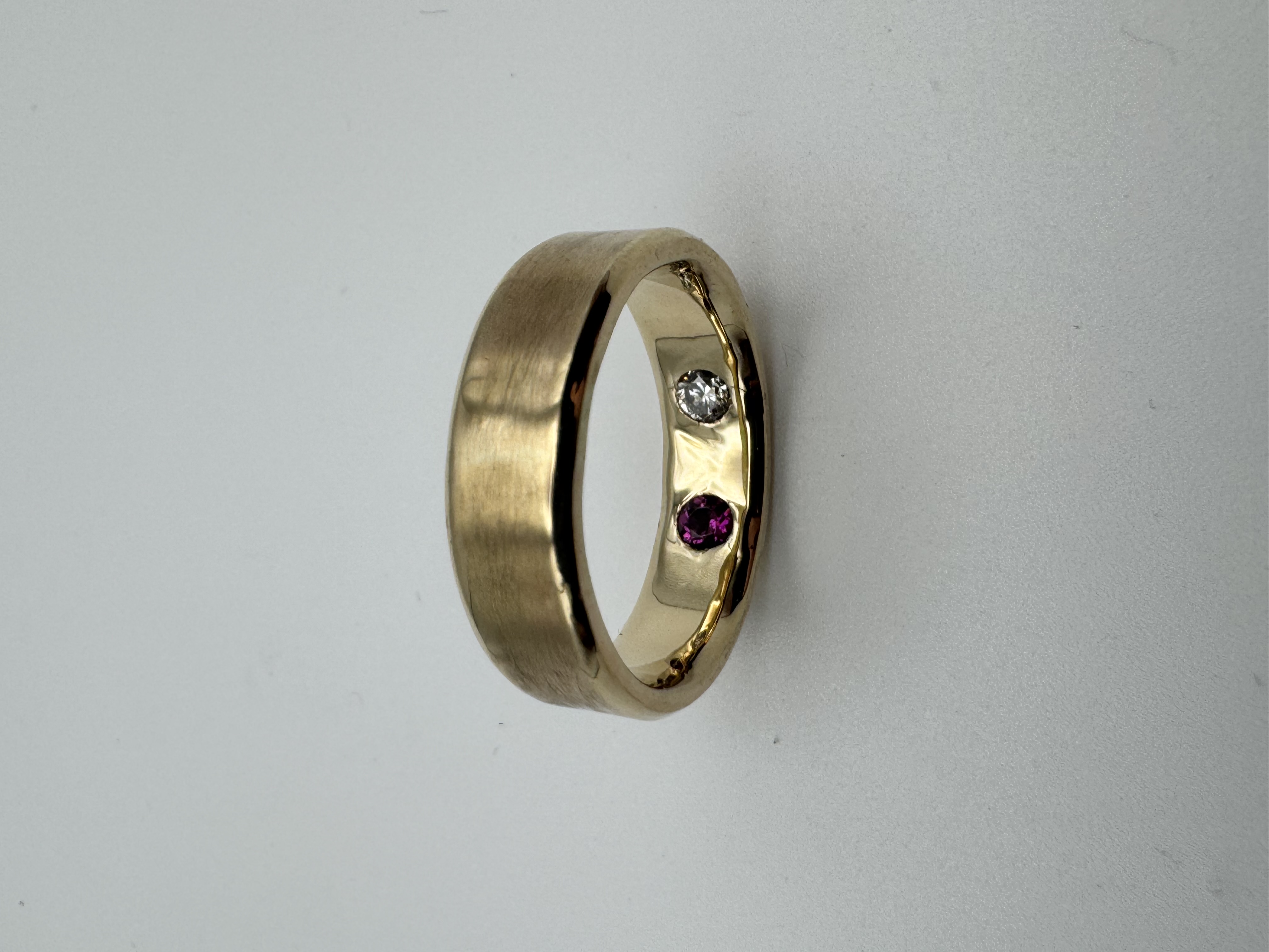 Gold band with hidden diamond and ruby set inside the band